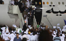 Libyan al-Megrahi is helped by relatives as he walks down the stairs upon his arrival at airport in Tripoli