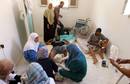 Dos hombres reciben asistencia m&eacute;dica despu&eacute;s de haber resultado heridos durante los enfrentamientos en Bab al Aziyah, en Tr&iacute;poli.