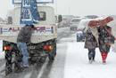 Un hombre trata de empujar su veh&iacute;culo, parado a causa de la nieve en la M-40 de Madrid.