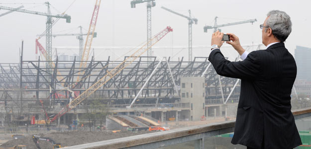 A man photographs the main Olympic Stadium construction at Stratford in east London