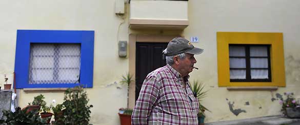 Un habitante de Sietes frente a una de las casas decoradas con los colores corporativos de Windows en el peque&ntilde;o pueblo asturiano. El jueves 22 de octubre tendr&aacute; lugar en este pueblo el evento de lanzamiento de Windows 7.