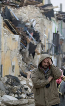 Un hombre mira desolado la destrucci&oacute;n a su alrededor en Onna.