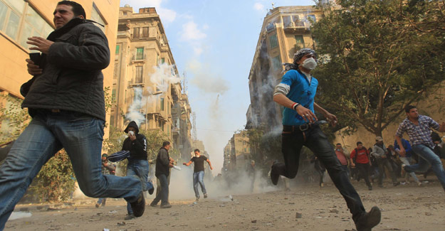 Manifestantes egipcios huyen de los gases lacrim&oacute;genos en El Cairo