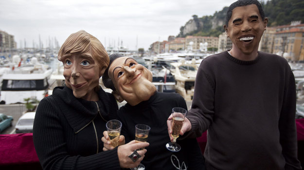 Manifestantes con máscaras de Ángela Merkel, Nicolás Sarkozy y Barack Obama, en Niza