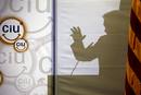 La silueta del candidato de Convergencia i Uni&oacute; a la presidencia de la Generalitat, Artur Mas, reflejada en un papel durante su intervenci&oacute;n en un almuerzo con medio millar de j&oacute;venes en el Palacio de Congresos de Catalu&ntilde;a
