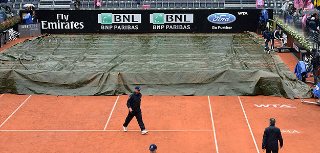 Los operarios del Masters 1000 de Roma tapan la pista con una lona por la lluvia.