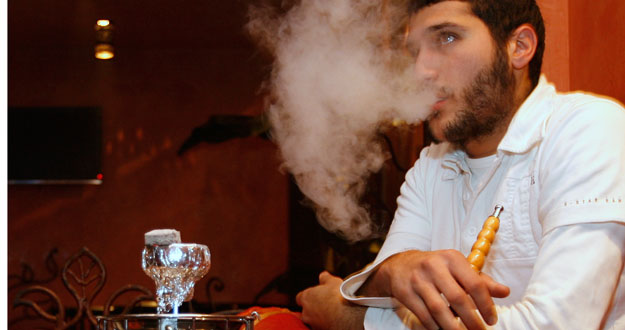 Un hombre fuma 'shisha' en un bar de Par&iacute;s.