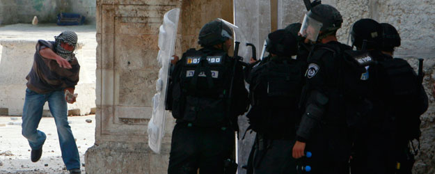A Palestinian throws a stone at Israeli police during clashes in Jerusalem's Old City