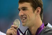 Michael Phelps sonr&iacute;e con su medalla de oro.
