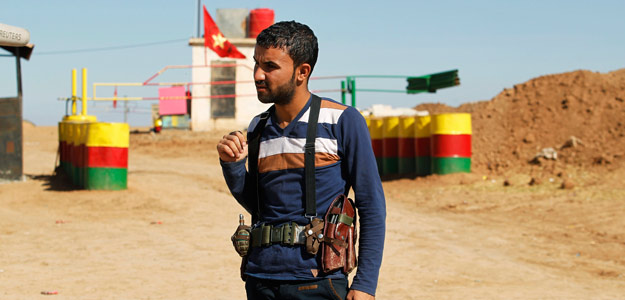 Un miembro de la milicia del Partido de la Unión Democrática (PYD) hace guardia junto a un puesto de control en la frontera sirio-iraquí