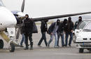 Hooded police walk near the plane with on board suspected Basque separatist rebel group ETA military chief Garikoitz Aspiazu Rubina at the Biarritz airport