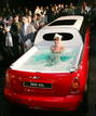A model wearing a bikini soaks in a jacuzzi on the rear end of a limousine named 