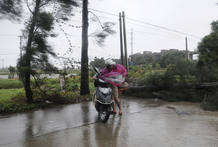 Una motorista lucha contra el fuerte viento en Changle, en la provincia de Fujian. Una motorista lucha contra el fuerte viento en Changle, en la provincia de Fujian.
