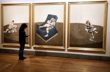 Una mujer observa la obra "Tres figuras en una habitaci&oacute;n"