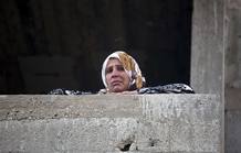 Una mujer palestina observa los restos de un coche destruido por un ataque aéreo israelí