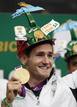El nadador sudafricano Cameron van der Burgh que consigui&oacute; el oro ol&iacute;mpico muestra su medalla a los aficionados durante su llegada a el Aeropuerto Internacional OR Tambo de Johannesburgo.