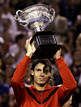 Spains Nadal holds up the trophy after winning his mens singles final match against Switzerlands Federer at the Australian Open