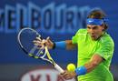 Nadal devuelve una bola con su rev&eacute;s a Novak Djokovic