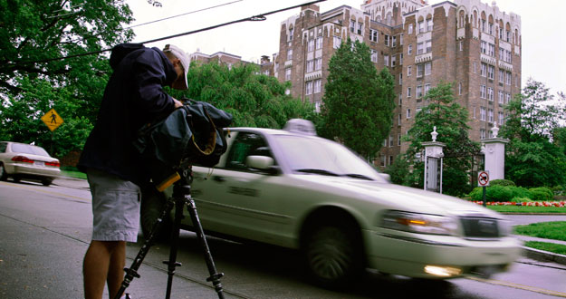 A news TV cameraman films outside the residence of accused spies Walter and Gwendolyn Myers in Washington