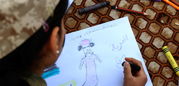 Una niña libia dibuja una caricatura de Gadafi junto con la palabra "Libertad", en Bengazi Una niña libia dibuja una caricatura de Gadafi junto con la palabra "Libertad", en Bengazi
