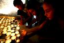 Varios ni&ntilde;os israel&iacute;es encienden velas cerca de la casa de Eldad Regev el d&iacute;a en que han llegado a Israel los ata&uacute;des con sus restos mortales desde el L&iacute;bano.