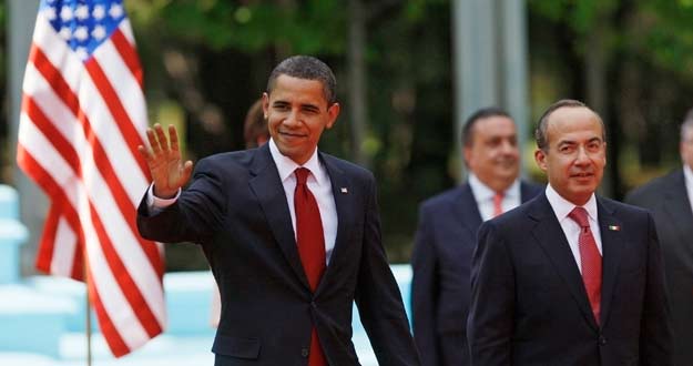 U.S. President Obama waves as he walks with Mexico's President Calderon in Mexico City