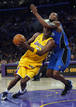 El jugador de los &Aacute;ngeles Lakers, Odom, trata de llegar al aro defendido por Lewis, de los Orlando Magic durante el primer partido de la final de la NBA.