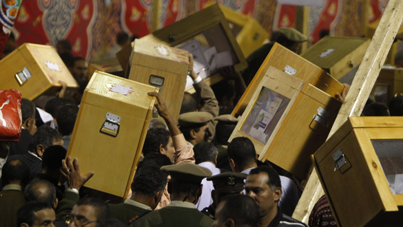 Oficiales de polic&iacute;a portan las urnas con los votos de las elecciones en Egipto