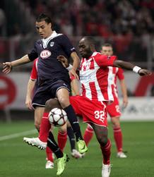 El jugador del Girondins de Burdeos Marouane Chamakh pelea por el bal&oacute;n con Lomana LuaLua, del Olympiacos.