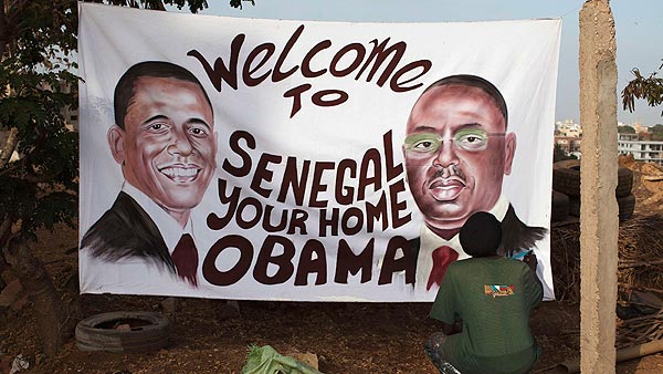 Ouzin, artista plástico, pone el toque final en Dakar a un cartel que da la bienvenida a Obama a Senegal