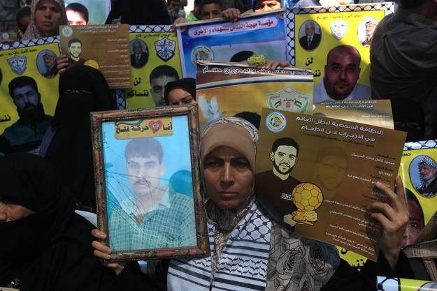 Palestinos con carteles del futbolista en huelga de hambre, Mahmud Sarsak, y de Akram Rijawi, otro de los presos en huelga Palestinos con carteles del futbolista en huelga de hambre, Mahmud Sarsak, y de Akram Rijawi, otro de los presos en huelga