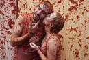 Una pareja cubierta de tomate se besa durante la Tomatina de Bu&ntilde;ol (Valencia)