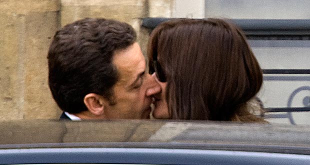 France's President Nicolas Sarkozy kisses first lady Carla Bruni-Sarkozy as they leave the Elysee Palace in Paris