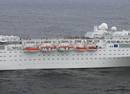 Pasajeros del Costa Allegra en cubierta. Debajo, los botes salvavidas.