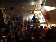 Pasajeros con los salvavidas puestos intentan salir en botes de rescate del crucero 'Costa Concordia'
