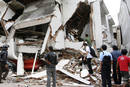 People stand near a collapsed shopping mall after an earthquake hit Padang, on Indonesias Sumatra island