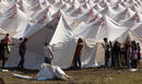 Personal de la Cruz Roja prepara una tienda de campa&ntilde;a en un campo de refugiados.