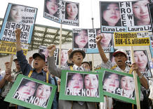 Conservative protesters shout slogans as they hold portraits of US journalists Euna Lee and Laura Ling in Seoul