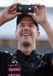 El piloto alem&aacute;n de F&oacute;rmula Uno Sebastian Vettel, de Red Bull, utiliza su tel&eacute;fono para fotografiar a los aficionados que le siguen en la competici&oacute;n.