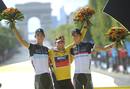 El corredor australiano del BMC, Cadel Evans, celebra en el podio su victoria en la clasificaci&oacute;n general del Tour de Francia, junto a los hermanos luxemburgueses del Leopard-Trek, Andy, segundo, y Frank Schleck, tercero.