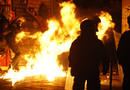 Los polic&iacute;as se protegen de un c&oacute;ctel molotov durante los disturbios de Atenas