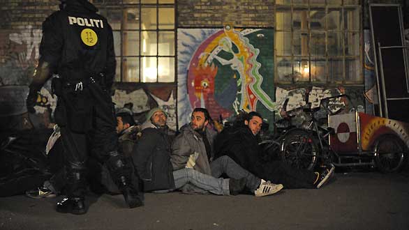 Un policía anti-motines danés vigila a un grupo de activistas en Copenhague Un policía anti-motines danés vigila a un grupo de activistas en Copenhague