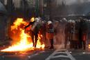 La polic&iacute;a antidisturbios lidia en el terreno contra las bombas incendiarias que lanzan los manifestantes