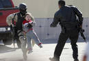 Un polic&iacute;a cargando con un ni&ntilde;o durante un tiroteo en Tijuana, en el estado mexicano de Baja California