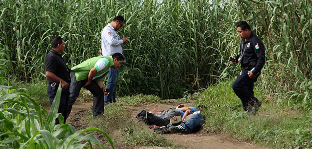 Policías y forenses examinan la escena del crimen donde fue encontrado el periodista mexicano Alberto López Bello.
