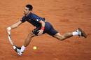 Postura inveros&iacute;mil de Djokovic para devolver la bola.