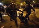Protester cries out as she is dragged away by riot police outside Spains parliament in Madrid