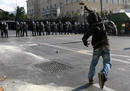 A protester throws a stone at policemen guarding Greeces parliament in Athens