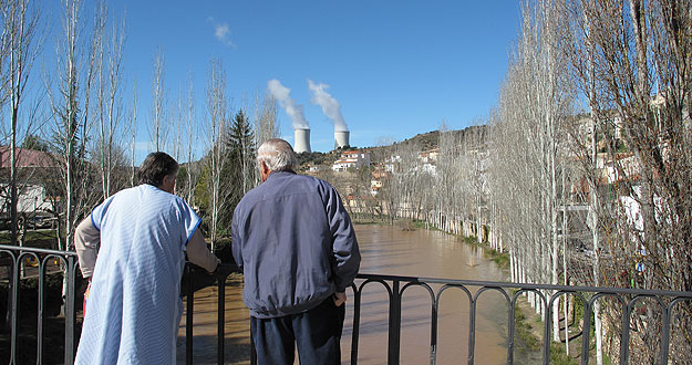Dos vecinos de Trillo miran el cauce del río Tajo con las torres de la central nuclear al fondo. Dos vecinos de Trillo miran el cauce del río Tajo con las torres de la central nuclear al fondo.