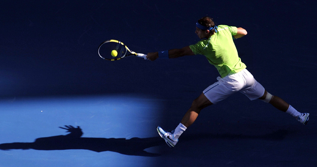 El tenista espa&ntilde;ol Rafael Nadal devuelve la bola al estadounidense Alex Kuznetsov.